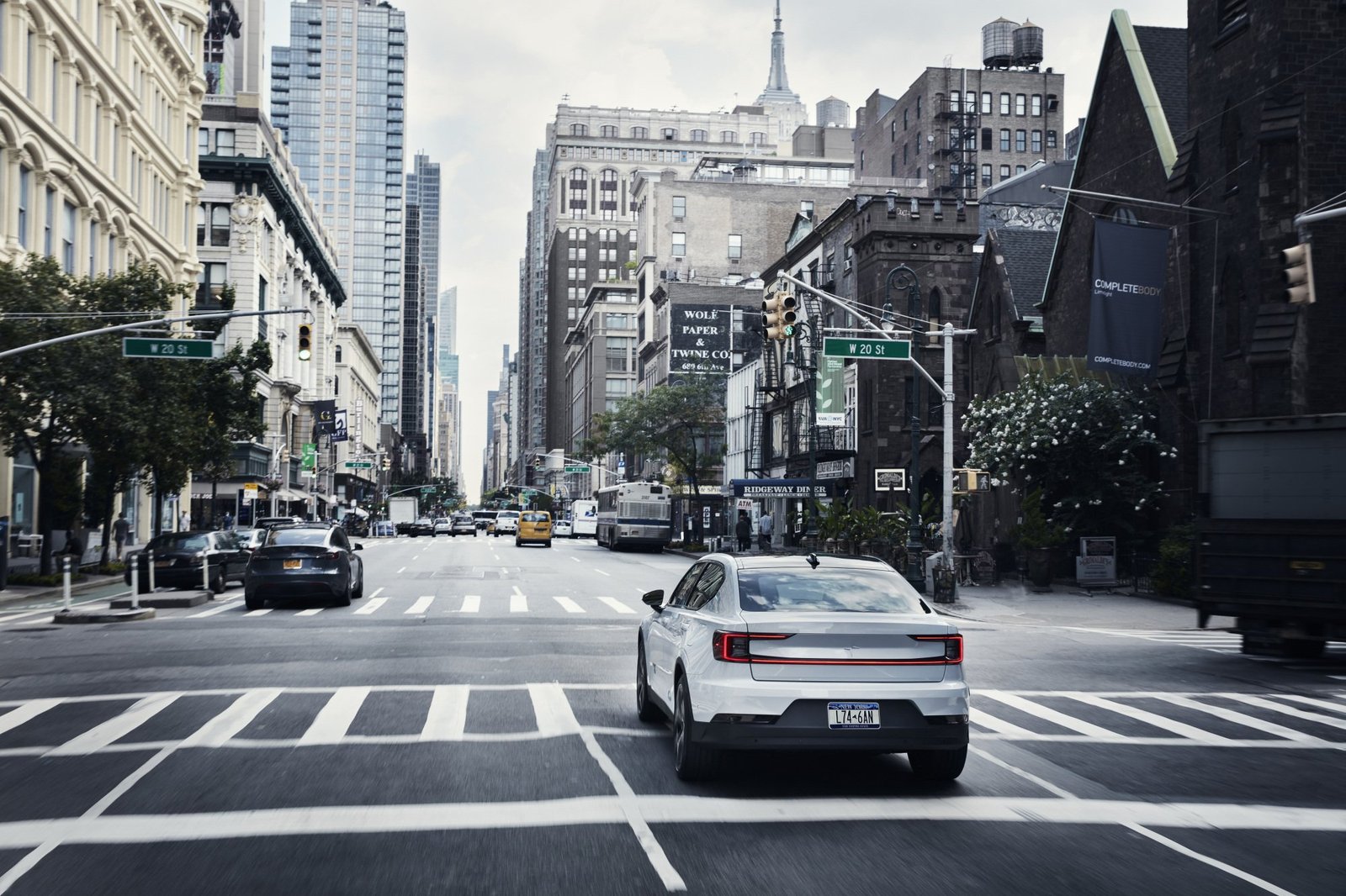 A photo of a white Polestar 2 driving on a road.